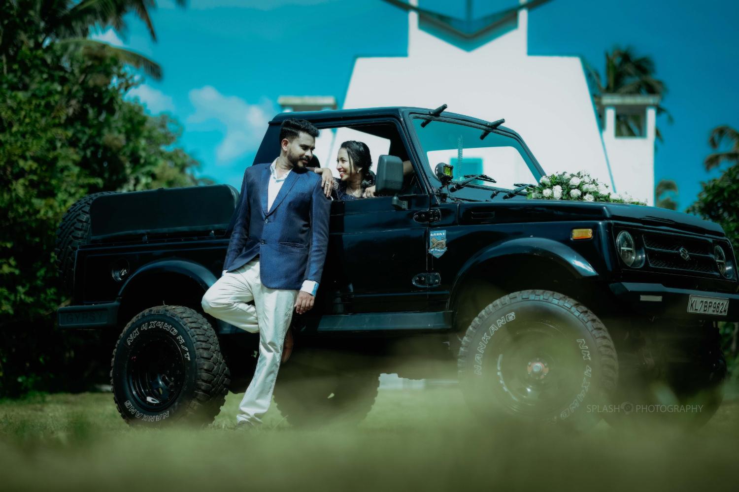 Joji and Bismi beside a black Gypsy, dressed for a celebration