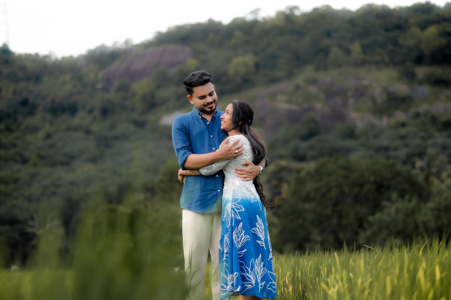 Joji and Bismi embracing on a hillside